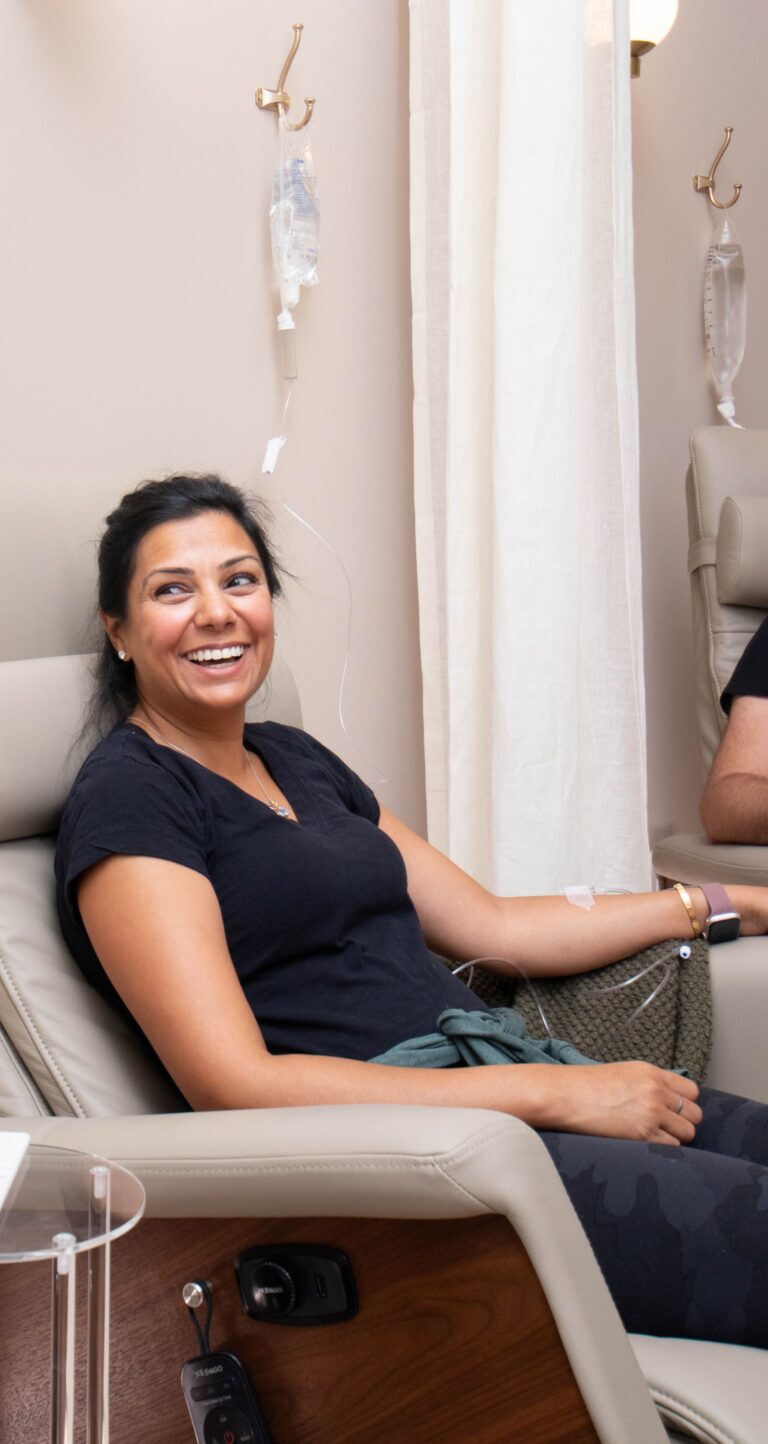 Happy woman in black shirt undergoing IV therapy