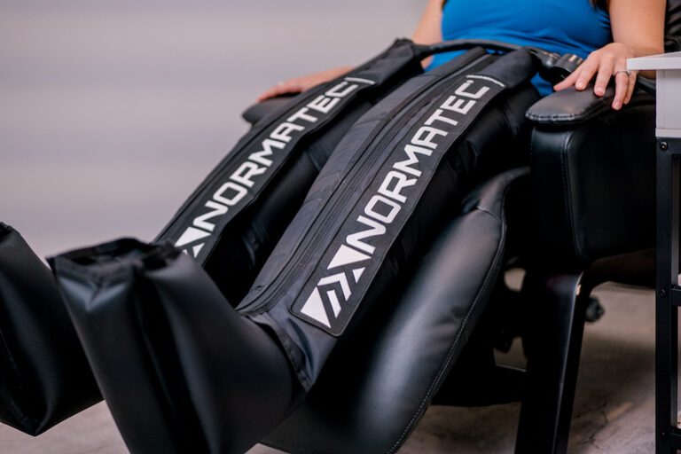 A woman using Normatec for compression therapy